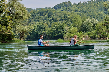 Image showing friends are canoeing in a wild river