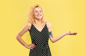 Image showing Caucasian young woman\'s half-length portrait on yellow background