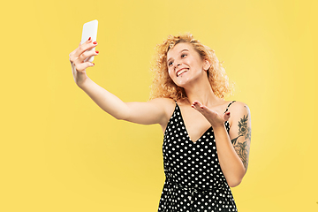 Image showing Caucasian young woman\'s half-length portrait on yellow background