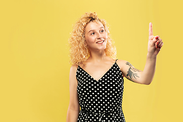 Image showing Caucasian young woman\'s half-length portrait on yellow background