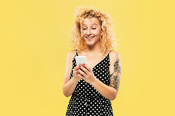 Image showing Caucasian young woman\'s half-length portrait on yellow background