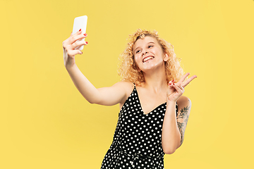 Image showing Caucasian young woman\'s half-length portrait on yellow background