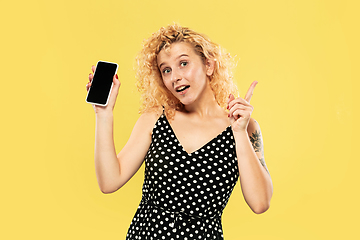 Image showing Caucasian young woman\'s half-length portrait on yellow background