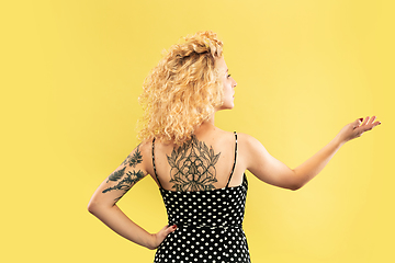 Image showing Caucasian young woman\'s half-length portrait on yellow background