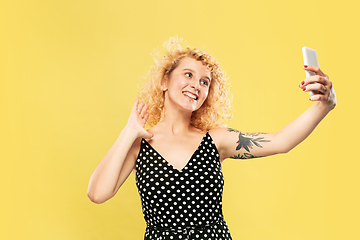 Image showing Caucasian young woman\'s half-length portrait on yellow background