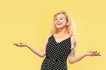 Image showing Caucasian young woman\'s half-length portrait on yellow background