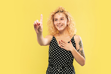 Image showing Caucasian young woman\'s half-length portrait on yellow background