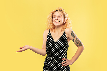 Image showing Caucasian young woman\'s half-length portrait on yellow background