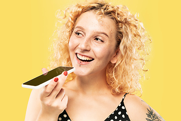 Image showing Caucasian young woman\'s half-length portrait on yellow background