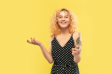 Image showing Caucasian young woman\'s half-length portrait on yellow background