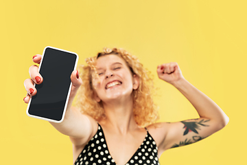 Image showing Caucasian young woman\'s half-length portrait on yellow background