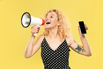 Image showing Caucasian young woman\'s half-length portrait on yellow background