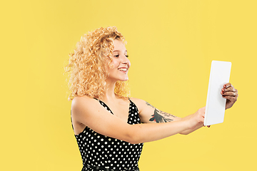 Image showing Caucasian young woman\'s half-length portrait on yellow background