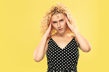 Image showing Caucasian young woman\'s half-length portrait on yellow background