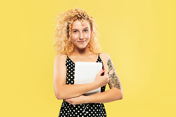 Image showing Caucasian young woman\'s half-length portrait on yellow background