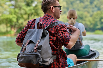 Image showing friends are canoeing in a wild river