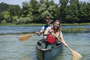 Image showing friends are canoeing in a wild river