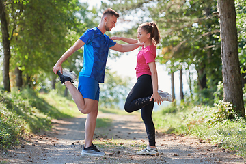 Image showing couple enjoying in a healthy lifestyle warming up and stretching before jogging