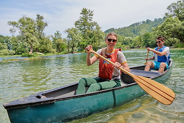 Image showing friends are canoeing in a wild river