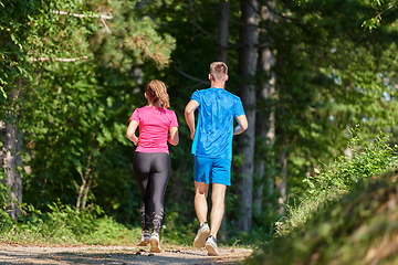 Image showing couple enjoying in a healthy lifestyle while jogging on a country road