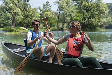 Image showing friends are canoeing in a wild river