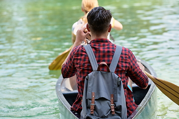 Image showing friends are canoeing in a wild river