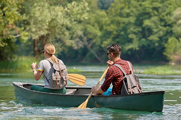 Image showing friends are canoeing in a wild river