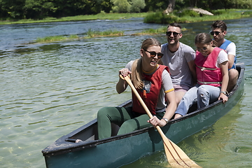 Image showing Group adventurous explorer friends are canoeing in a wild river