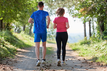 Image showing couple enjoying in a healthy lifestyle while jogging on a country road