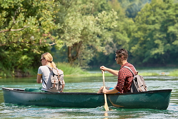 Image showing friends are canoeing in a wild river