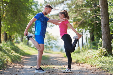 Image showing couple enjoying in a healthy lifestyle warming up and stretching before jogging