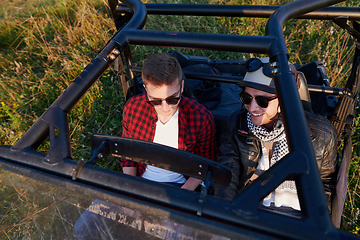 Image showing two young happy excited men enjoying beautiful sunny day while driving a off road buggy car