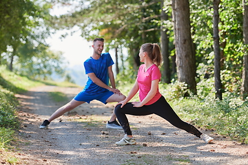 Image showing couple enjoying in a healthy lifestyle warming up and stretching before jogging