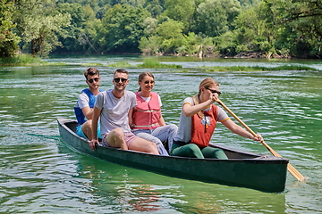 Image showing Group adventurous explorer friends are canoeing in a wild river