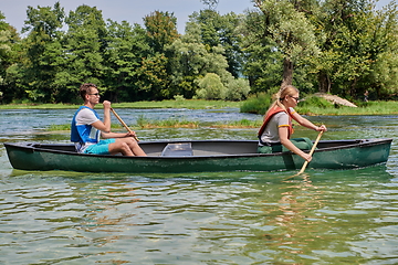 Image showing friends are canoeing in a wild river