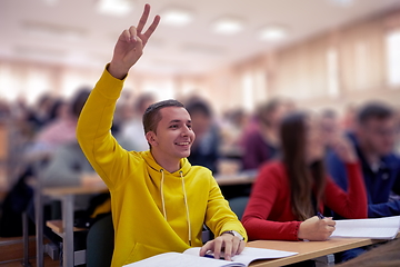 Image showing The student raises his hands asking a question in class in college