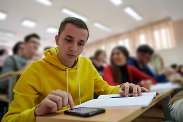 Image showing Student using a calculator while calculating in a math class