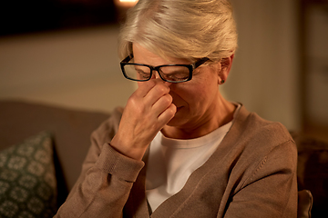 Image showing tired senior woman in glasses at home at night