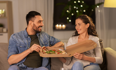 Image showing happy couple eating takeaway pizza at home