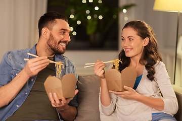 Image showing happy couple eating takeaway noodles at home