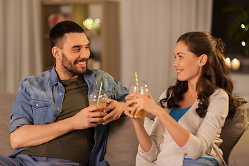 Image showing happy couple drinking takeaway juice at home