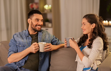 Image showing happy couple drinking tea or coffee at home