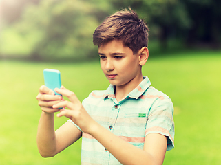 Image showing boy with smartphone playing game in summer park