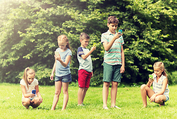 Image showing kids with smartphones playing game in summer park