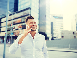 Image showing happy man with smartphone calling on city street