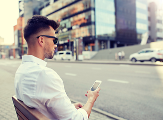 Image showing close up of man texting on smartphone in city