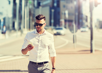 Image showing man in sunglasses with smartphone walking at city
