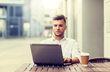 Image showing man with laptop and coffee at city cafe