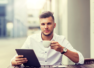 Image showing man with tablet pc and coffee at city cafe