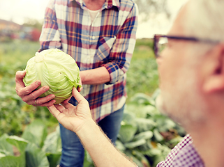 Image showing senior couple picking cabbage on farm